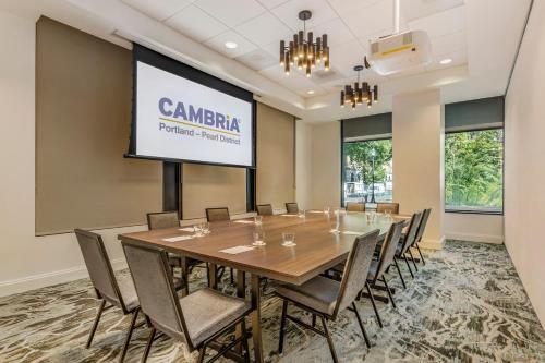a conference room with a table and chairs and a projection screen at Cambria Hotel Portland - Pearl District in Portland
