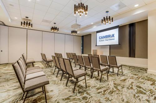 a conference room with chairs and a projection screen at Cambria Hotel Portland - Pearl District in Portland