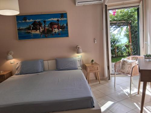 ein Schlafzimmer mit einem Bett und einem Tisch und einem Fenster in der Unterkunft villa incanto in Zambrone