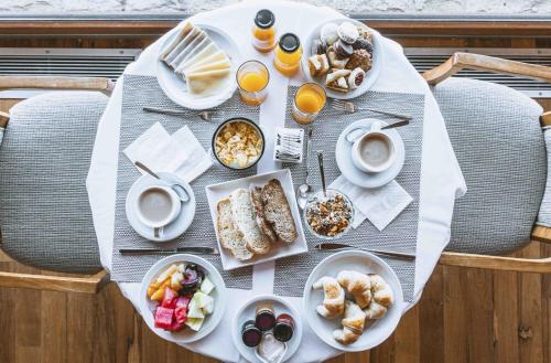 ein Tisch mit Frühstücksspeisen und Getränken darauf in der Unterkunft El Faro Boutique Hotel & Spa by DON in Villa La Angostura