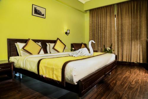 a bedroom with a bed with a swan on it at Hotel Preethi Classic Towers in Ooty