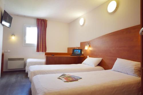a hotel room with two beds and a television at Brit Hotel Reims La Pompelle in Reims