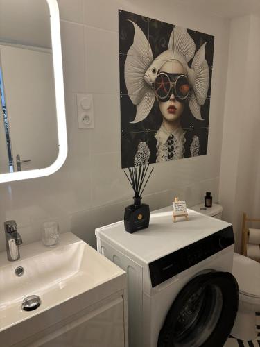 a bathroom with a painting of a woman wearing sunglasses at La cour d Anvers in Dieppe