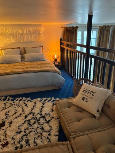 a bedroom with a bed and a couch and a rug at La cour d Anvers in Dieppe