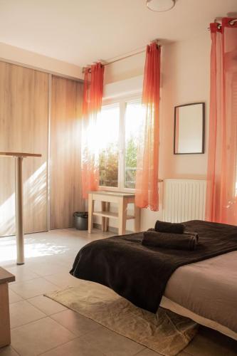 a bedroom with a large bed with red curtains at Studio - Piscine, proche du golf in Juvignac