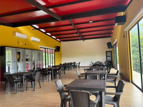 a dining room with tables and chairs and red ceilings at hacienda hotel texas in Durania