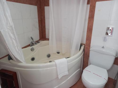 a bathroom with a tub and a toilet and a sink at Rethymno Mare & Water Park in Rethymno Town