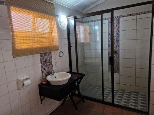 a bathroom with a sink and a shower at The Comfort Zone - Mthatha in Mthatha