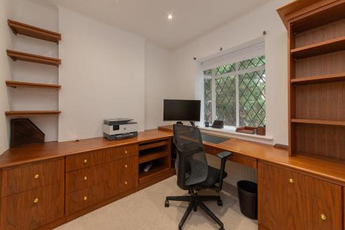 an office with a desk with a computer and a chair at Elegant Tudor Venue in Stone Grove