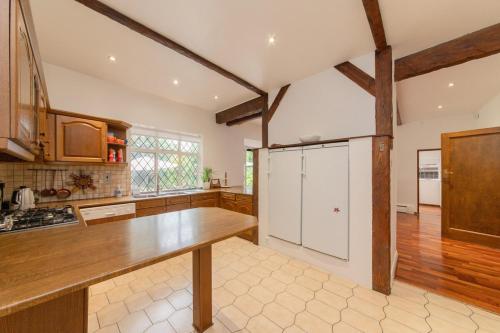 a kitchen with white cabinets and a wooden counter top at Elegant Tudor Venue in Stone Grove