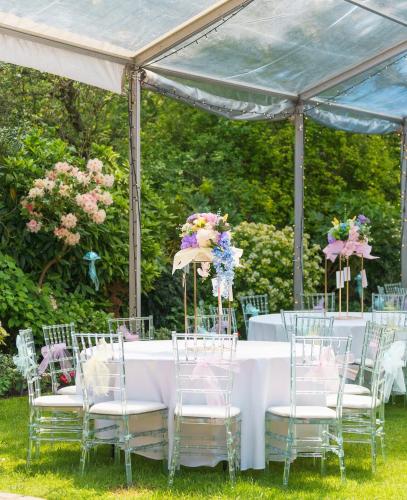 a table and chairs under a tent with flowers at Elegant Tudor Venue in Stone Grove