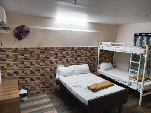 a room with two bunk beds and a fan at Aurobay Resorts Pondicherry in Auroville
