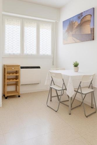 a white dining room with a table and chairs at bilocale vicino alla metro in Brescia