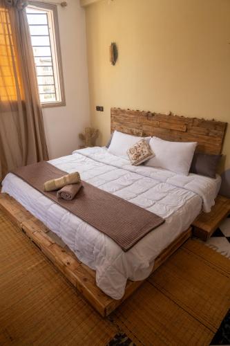 Un dormitorio con una cama grande con sábanas blancas y una ventana. en The Flow Host, en Tamraght Ouzdar