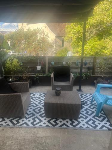 a patio with chairs and a table on a rug at Studio près de l aéroport d Orly in Orly