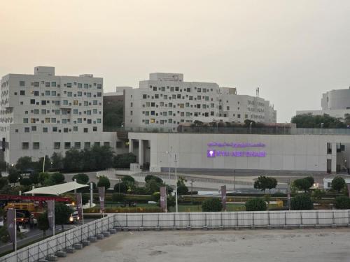 a large building with a purple sign in front of it at Luxury 2-Bedroom APT - Sea Views in Saadiyat Island in Abu Dhabi