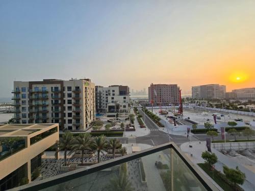 a view of a city at sunset from a building at Luxury 2-Bedroom APT - Sea Views in Saadiyat Island in Abu Dhabi