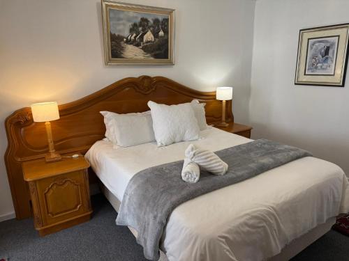 a bedroom with a large bed with two lamps and a bed sidx sidx sidx sidx at The Royal Lodge in Beaufort West