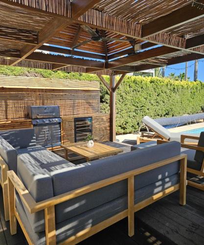 an outdoor patio with a couch and a grill at Villa del Mar in Mazotos
