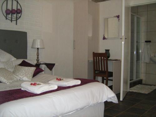 a bedroom with a bed with towels on it at Ukarimu Guest House in Klerksdorp