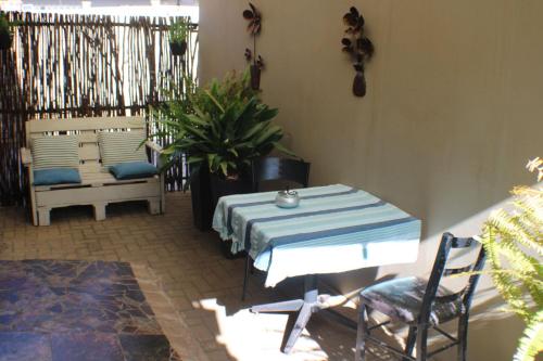 a patio with a table and chairs and a plant at Ukarimu Guest House in Klerksdorp