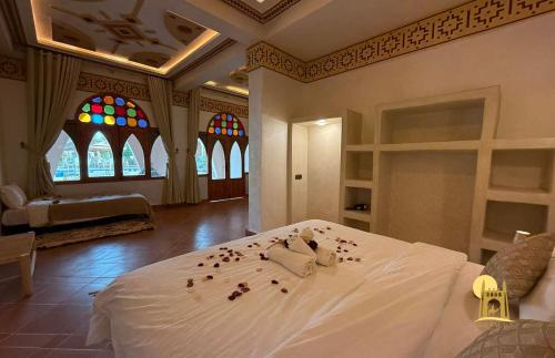 a bedroom with a bed with rose petals on it at hotel riad kasbah sbai palace in Mhamid