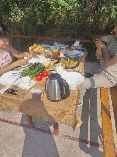 un gruppo di persone sedute attorno a un tavolo con del cibo di Syuzn Resort a Goris