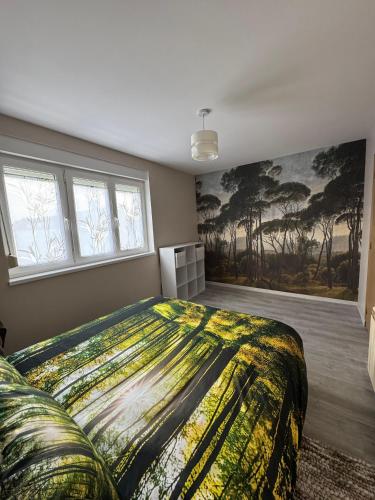 a bedroom with a large bed and a painting on the wall at Gite accueillant et confortable in Etreux