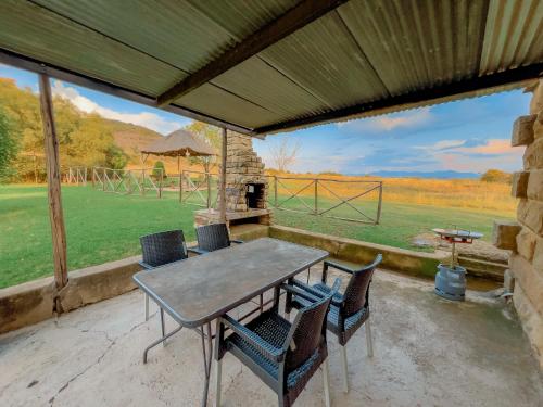 a patio with a table and chairs and a grill at Camelroc Guest Farm in Fouriesburg