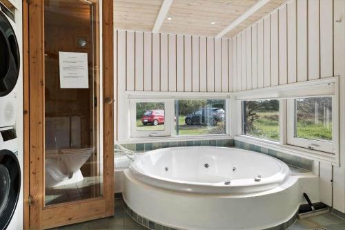 a large white tub in a bathroom with windows at TV1597-Albaek-Albaekvej-78 in Ålbæk