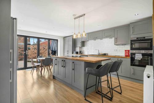 a kitchen with gray cabinets and a table with chairs at GuestReady - Charming Retreat in Trafford in Manchester