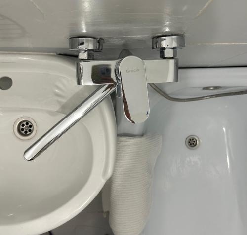 a bathroom with a sink and a toilet at Minimalist 2-room Apartment in Aktobe