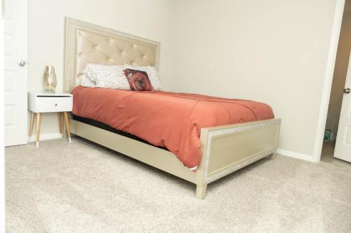 a bedroom with a bed with a orange comforter at Cozy Room with Private bath in Richmond, TX in Richmond