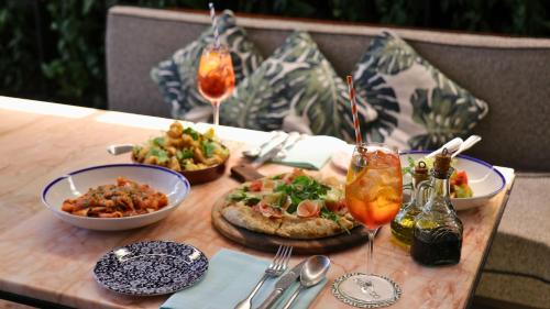 a table with plates of food and drinks on it at InterContinental Singapore Robertson Quay by IHG in Singapore