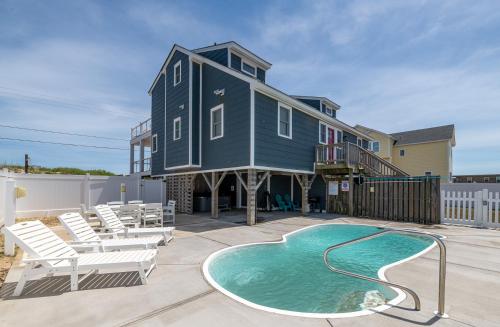 a house with a swimming pool and chairs and a house at Experience Ocean Views at Pinstripe Paradise, 5 BR, Pool, Pets OK! in Avalon Bench