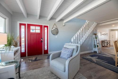 a living room with a red door and a chair at Experience Ocean Views at Pinstripe Paradise, 5 BR, Pool, Pets OK! in Avalon Bench
