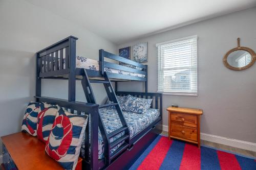 a bedroom with two bunk beds and a mirror at Experience Ocean Views at Pinstripe Paradise, 5 BR, Pool, Pets OK! in Avalon Bench