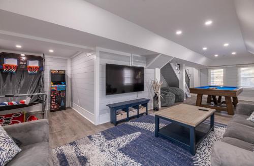 a living room with a couch and a tv and a table at Experience Ocean Views at Pinstripe Paradise, 5 BR, Pool, Pets OK! in Avalon Bench