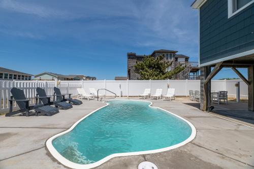 a small swimming pool with chairs on a patio at Experience Ocean Views at Pinstripe Paradise, 5 BR, Pool, Pets OK! in Avalon Bench