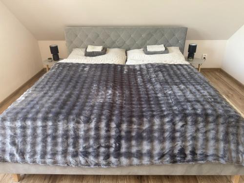 a bedroom with a large bed with a blanket on it at Tokajský domček in Malá Tŕňa