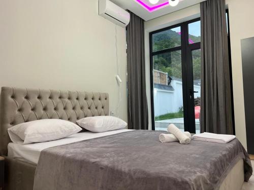 a bedroom with a large bed with a large window at Qafqaz Mandarin Deluxe in Gabala