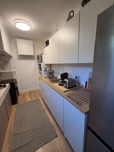 a kitchen with white cabinets and a counter top at Lorette Hideway in Saint-Tropez