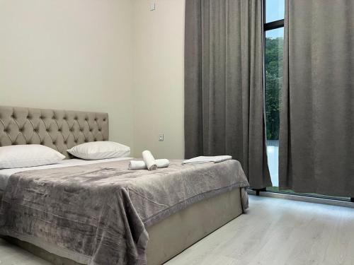 a bedroom with a bed and a large window at Qafqaz Mandarin Deluxe in Gabala