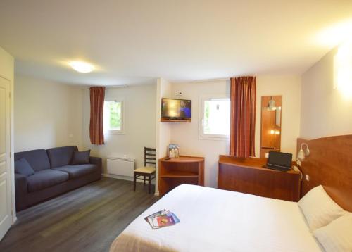 une chambre d'hôtel avec un lit et un canapé dans l'établissement Brit Hotel Reims La Pompelle, à Reims