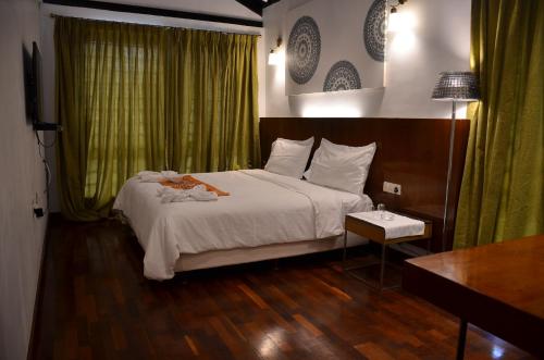 a bedroom with a bed and a desk and a television at ARYASREE homestay in Kodaikānāl