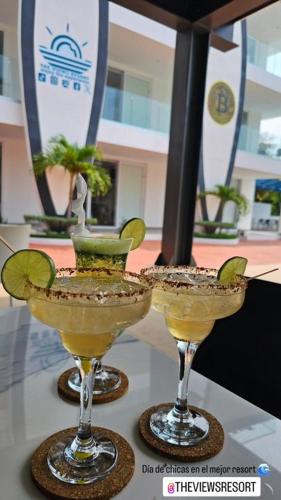 two martini glasses sitting on top of a table at The Views Resort in El Zonte