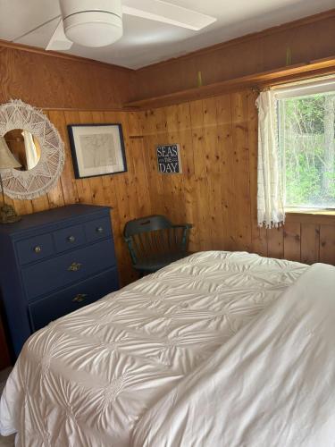 a bedroom with a bed and a dresser and a window at Latitude Adjustment in Traverse City