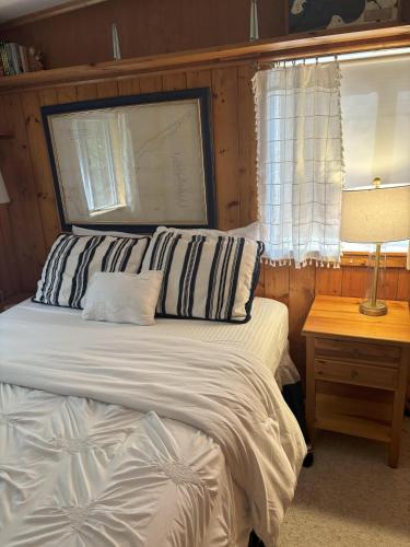 a bedroom with a bed and a table with a lamp at Latitude Adjustment in Traverse City