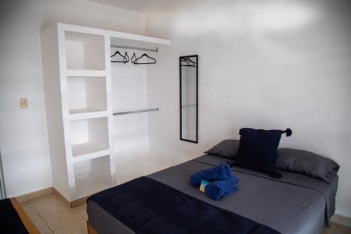 a bedroom with a bed with a blue object on it at La casa de Yaya in Puerto Escondido
