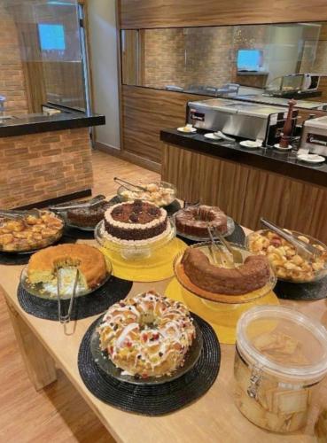 a table with many different cakes on top at FLAT 313 S4 Hotel in Brasilia